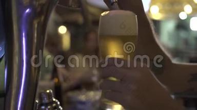 酒保在酒吧里用啤酒龙头倒啤酒到杯子里。 关闭啤酒手，将啤酒杯倒入玻璃从手柄水龙头